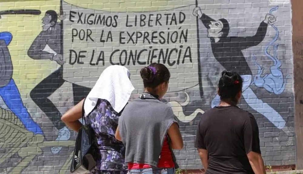 Jóvenes comentan un mural en la escuela normal de Ayotzinapa, en el municipio de Tixtla (Mèxico)