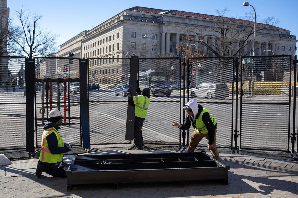 Trabajadores levantan vallas de seguridad en la Avenida Pensilvania, antes de la investidura presidencial de Donald Trump, en Washington.