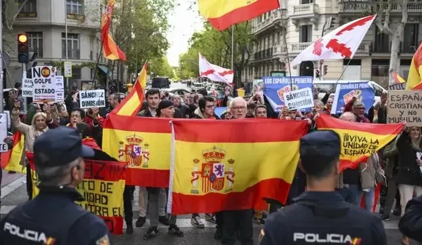 Asistentes a la manifestación para pedir la dimisión de Pedro Sánchez, este jueves en la calle de la sede del PSOE