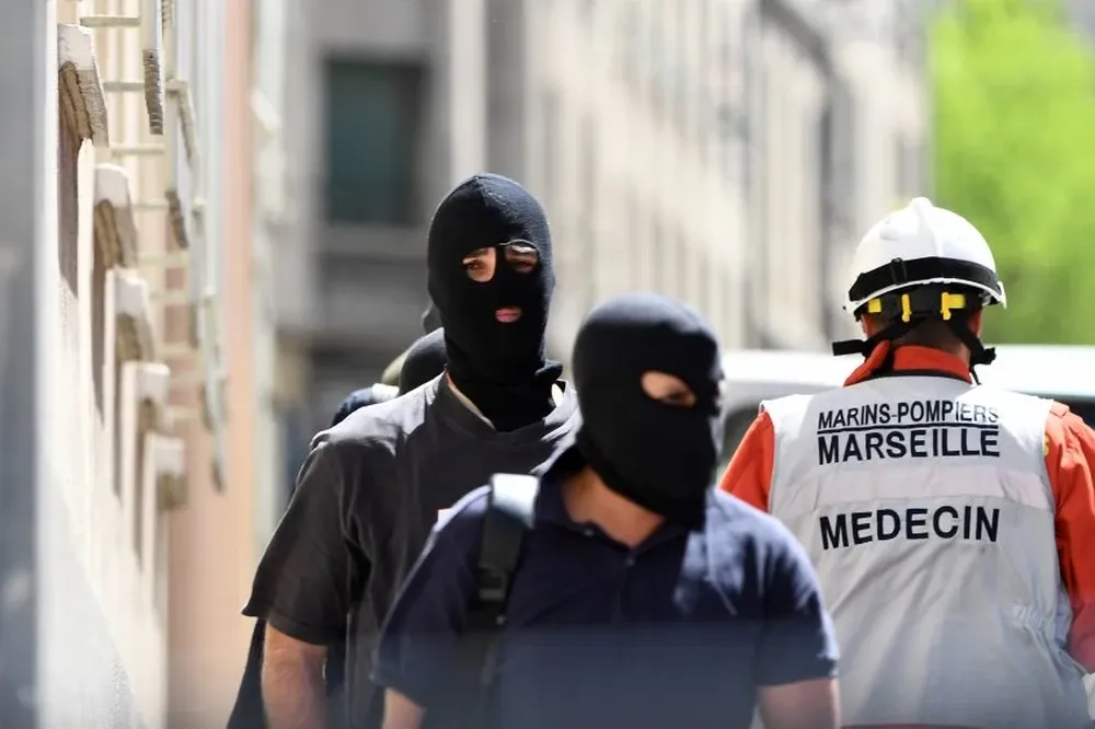 Los miembros de la Policía Judicial de Francia y un bombero naval salen tras una investigación policial.Boris HORVAT / AFP