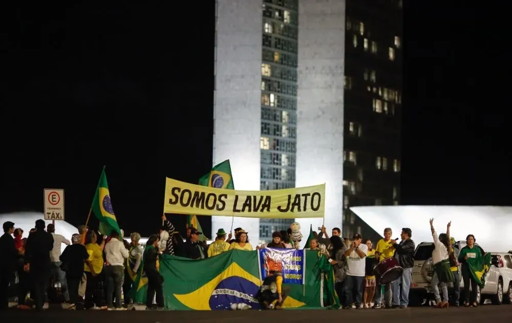 Un cartel que dice Somos Lava Jato aparece entre los manifestantes que celebran la condena de Lula