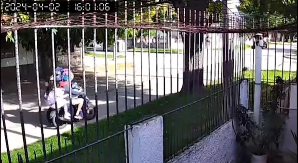 Momento en el que los delincuentes forcejean con el conductor de la moto