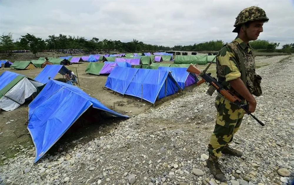 India- Un guardia de seguridad armado hace guardia cerca de un campamento de desplazados por la violencia étnica