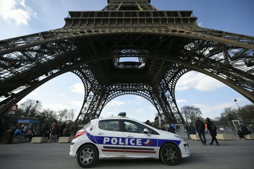 Un coche de policía estacionado frente a la torre Eiffel, en Francia, Paris
