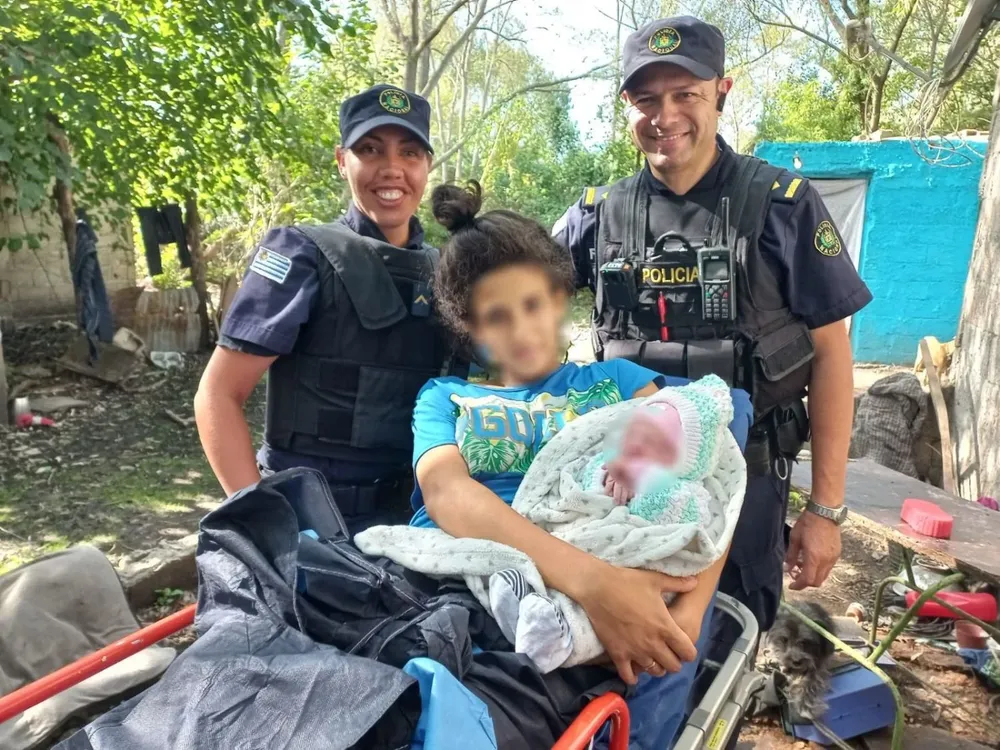 Los policías que asistieron el parto, la madre y la niña recién nacida