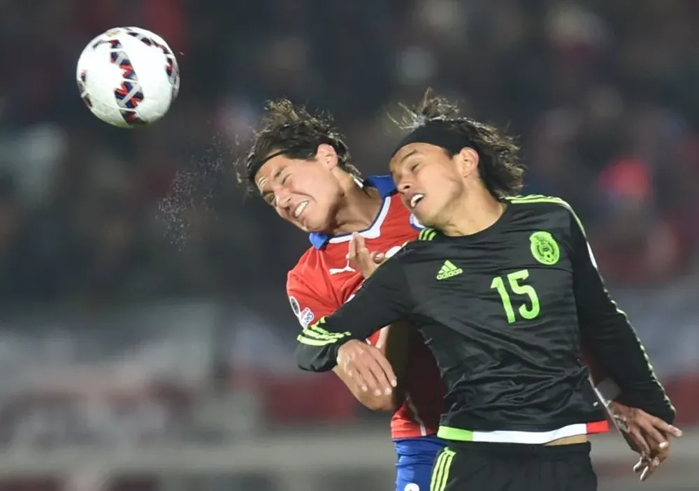 El defensor chileno Miiko Albornoz y el mexicano Gerardo Flores disputan el balón