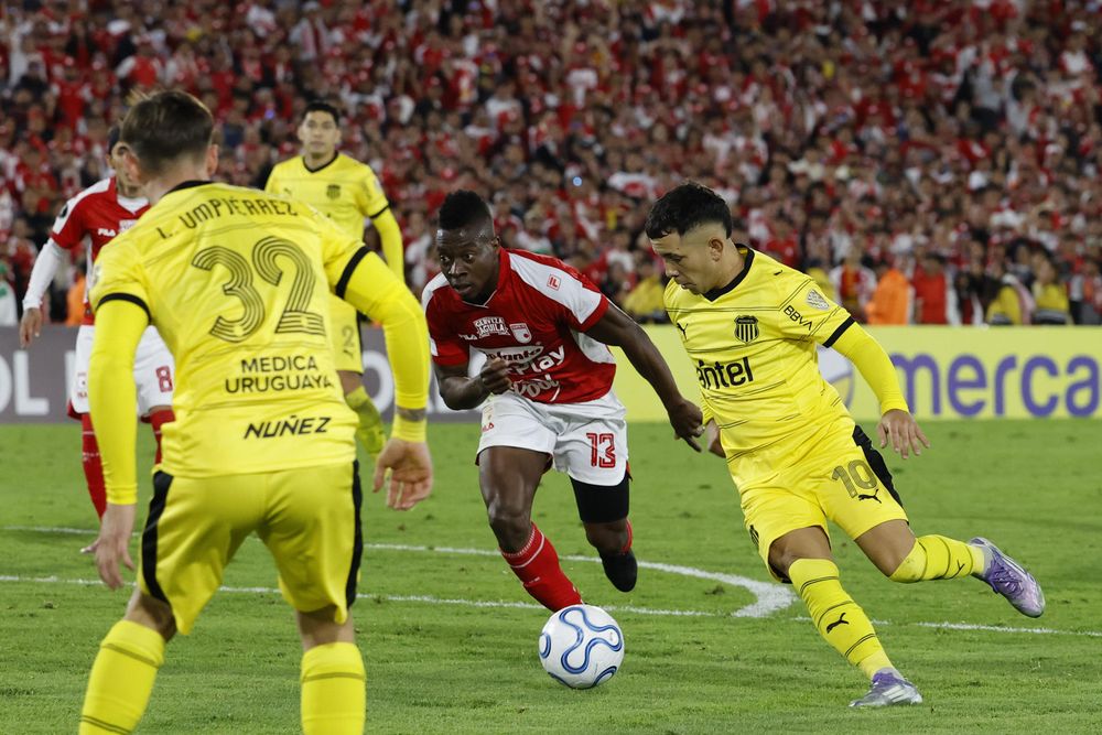 Palacios (c) de Santa Fe disputa el balón con Leo Fernández (d) de Peñarol&nbsp;