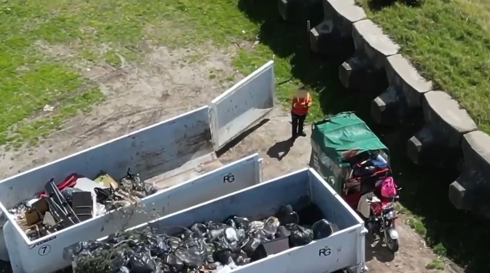 Momento en el que un motocarro deposita la basura
