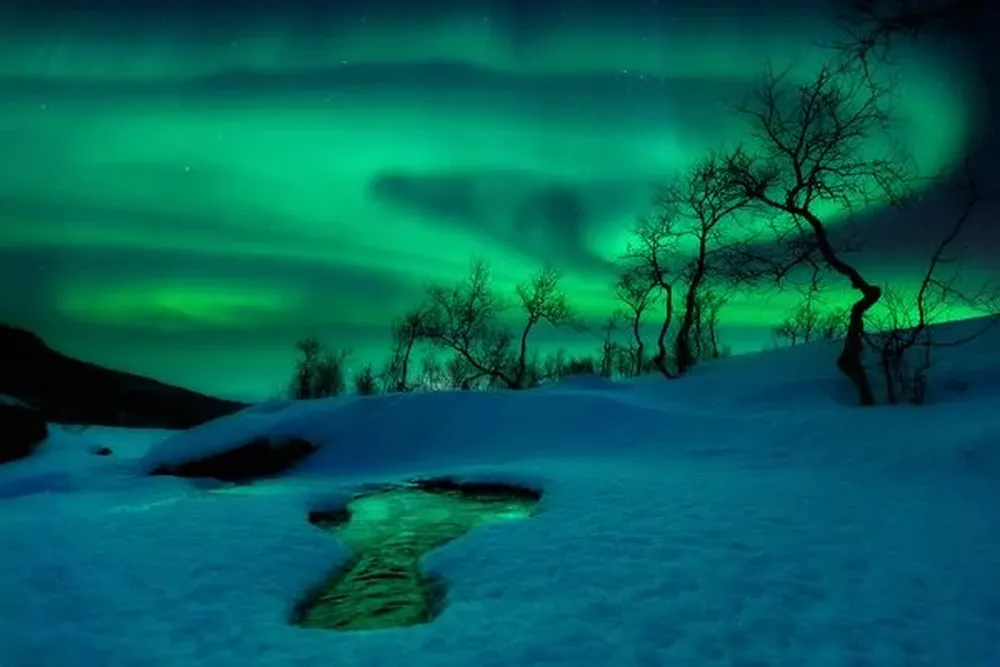 El fenómeno de las auroras, también conocidas como luces del norte, tienen lugar cuando ráfagas de viento solar chocan contra el campo magnético de la Tierra. Esto es precisamente lo que captó el fotógrafo Arild Heitmann