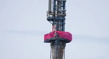 La lona rosada del Sí en lo alto de la refinería, desafiando disposiciones de seguridad