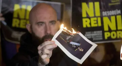 El concejal de la CUP en el Ayuntamiento de Barcelona Josep Garganté quema una foto del Rey