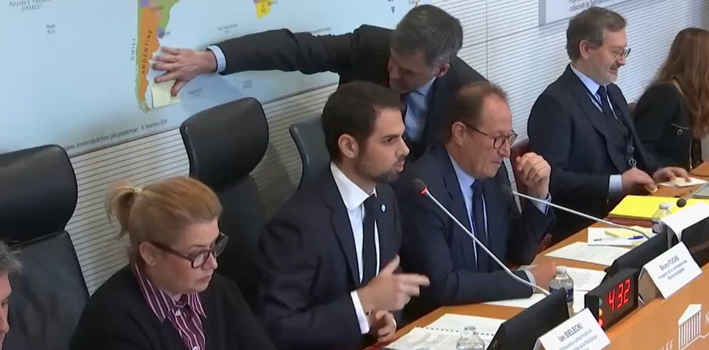 Un funcionario tapa las Islas Malvinas del mapa mientras habla el Embajador Ian Sielecki.