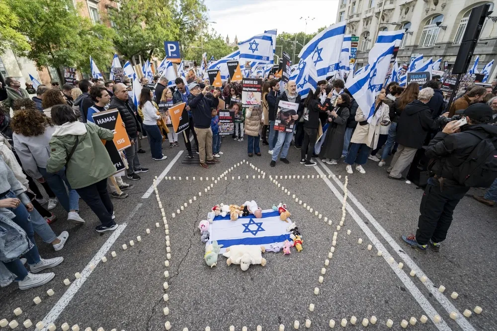 Una bandera y velas en el suelo durante una manifestación por la liberación de los rehenes secuestrados por Hamás, frente al Congreso de los Diputados en España.