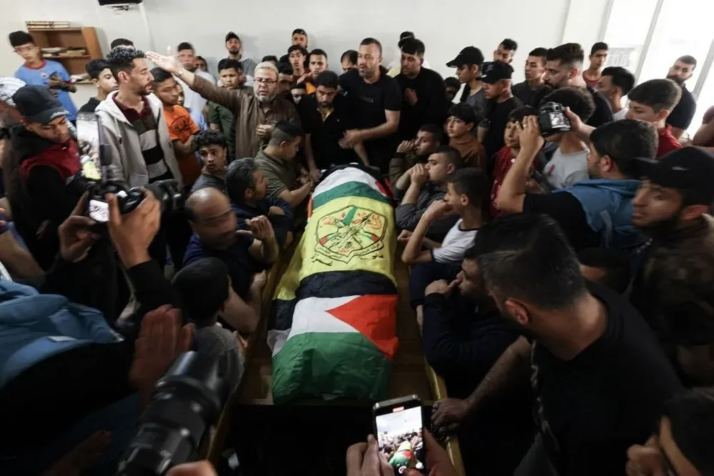 Varias personas llevan el cuerpo de uno de los palestinos asesinados