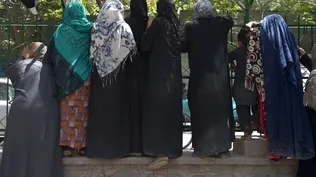 Las mujeres afganas desplazadas internamente, que huyeron de la provincia del norte debido a la batalla entre los talibanes y las fuerzas de seguridad afganas, se reúnen para recibir alimentos gratuitos distribuidos por hombres chiítas