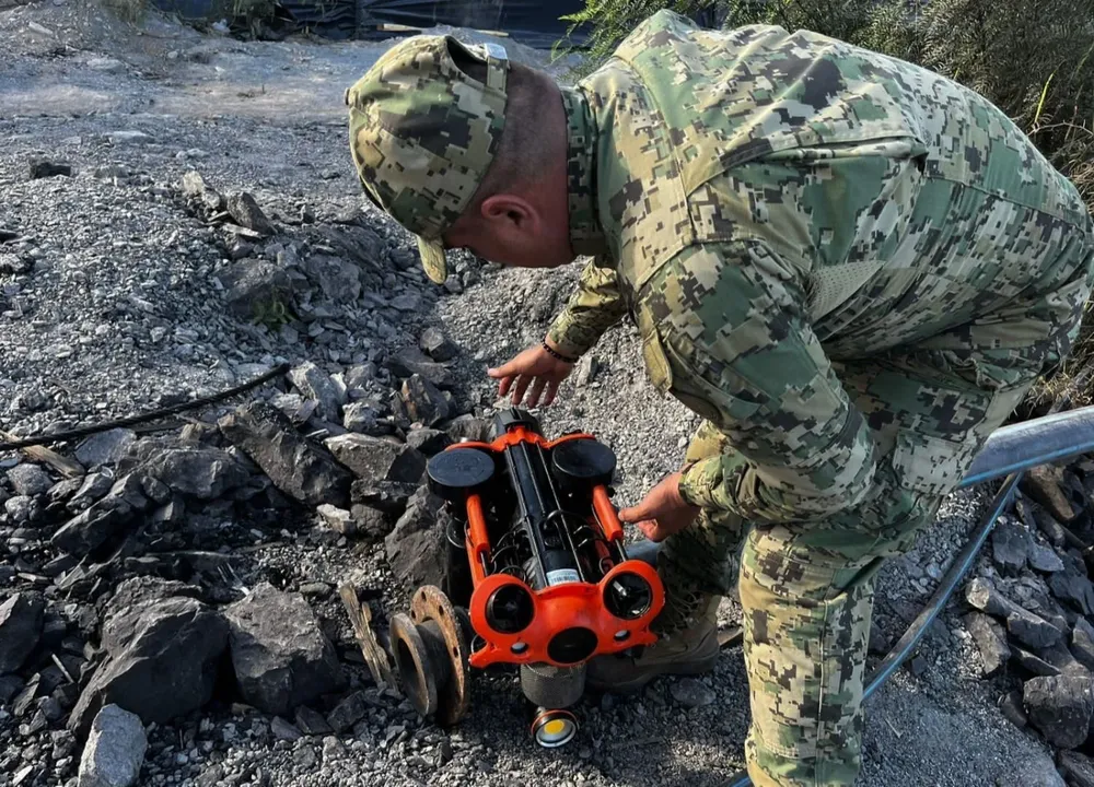 Un miembro del Sistema Nacional de Protección Civil mexicano instala una cámara en la mina donde 10 mineros fueron atrapados