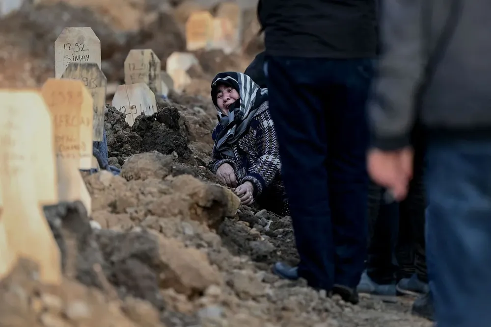 Una mujer llora sobre la tumba de sus seres queridos durante un funeral en la ciudad turca de Kahramanmaraş este viernes tras los terremotos del lunes