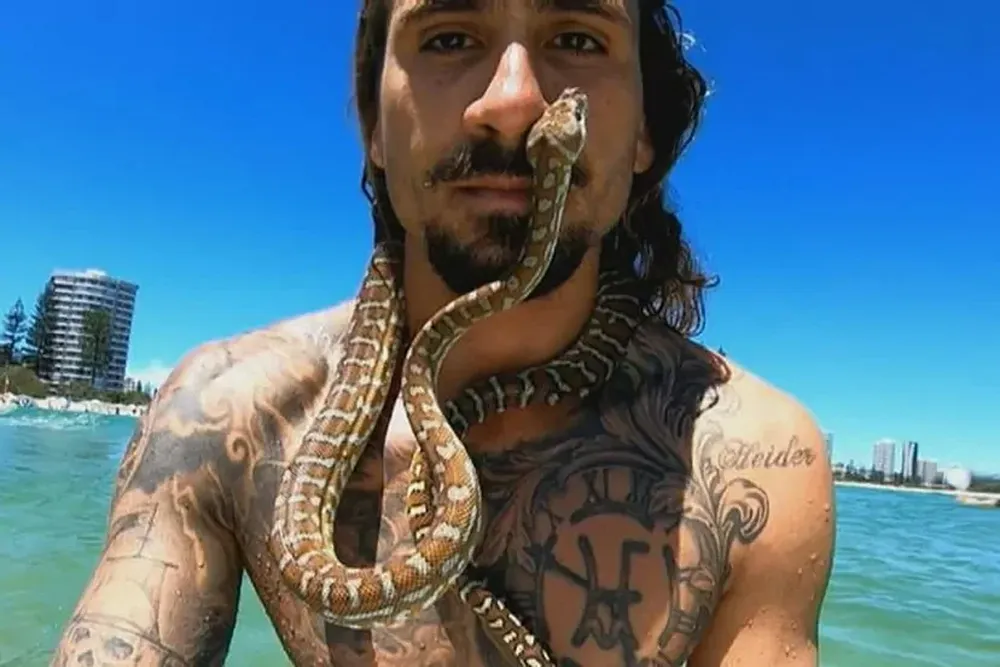 Higor Fiuza fue multado por surfear con su pitón.