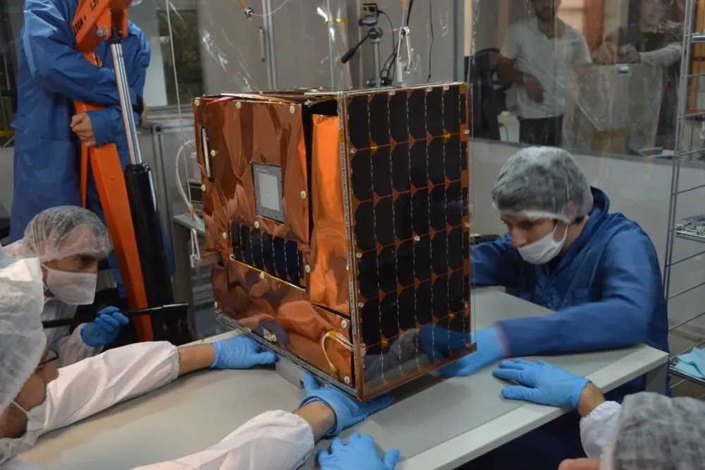 Empleados de Satellogic trabajando sobre un satélite.