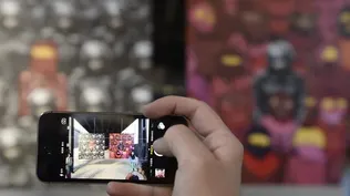 Un hombre toma una foto de una obra de arte callejera con su celular, en Nueva York