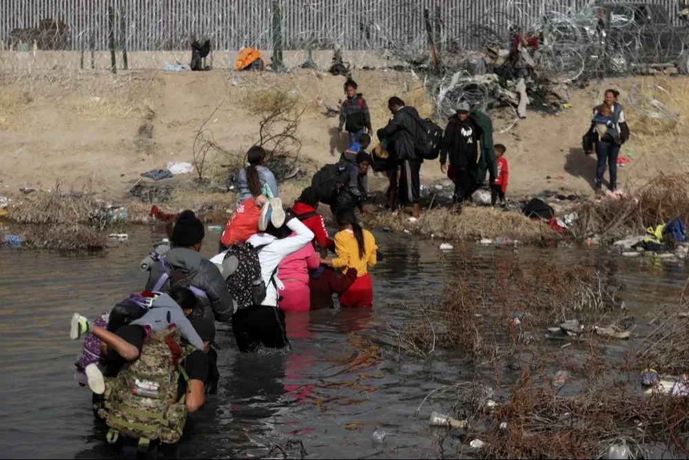 Migrantes ilegales atraviesan el Río Bravo en su intento por entrar a Estados Unidos.