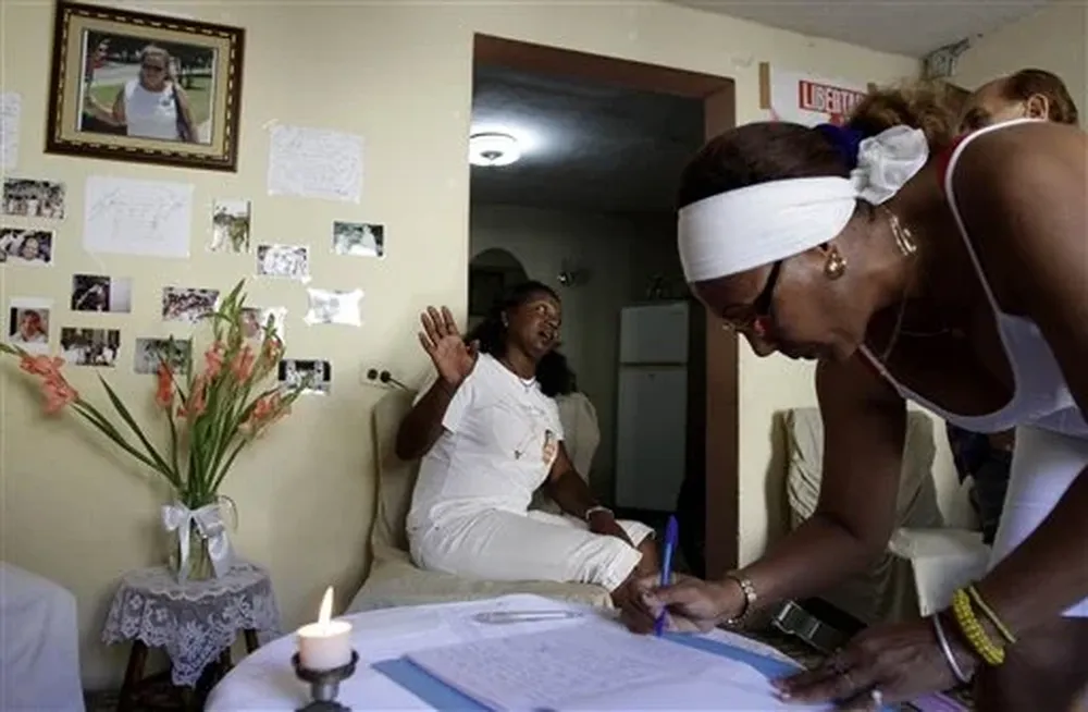 Integrantes del grupo disidente cubano Damas de Blanco firman un libro de condolencias por Wilman Villar