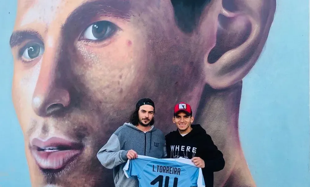 Lucas Torreira y José Gallino junto al mural que el artista realizó en Fray Bentos