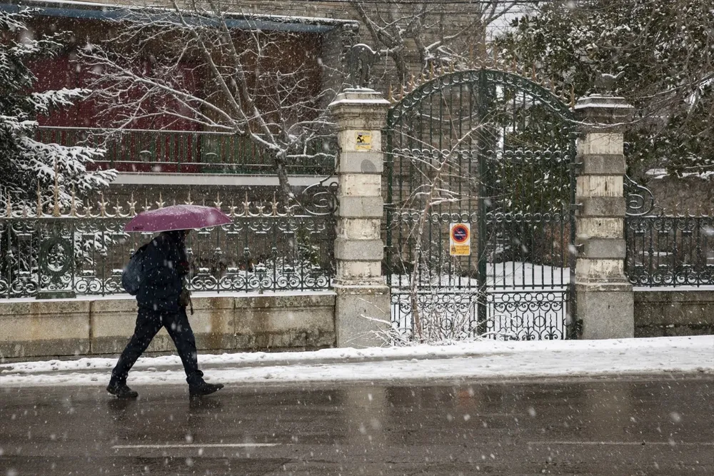 Un hombre camina bajo la nieve.