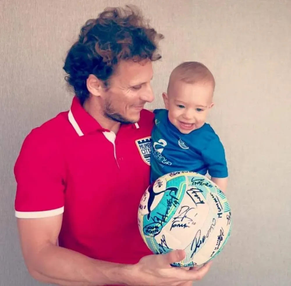Diego Forlán con su hijo Martín y la pelota ganada por su hat trick