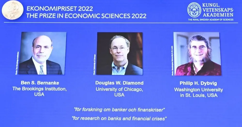 Una pantalla muestra a los tres estadounidenses ganadores del Premio Nobel de Economía