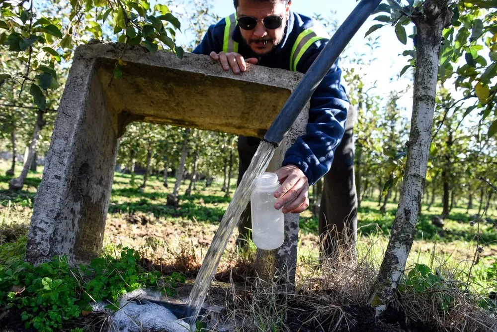 Funcionario de la IM tomando muestra de agua de un pozo