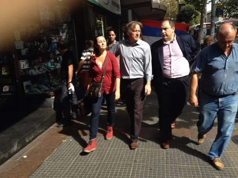 Lorenzo camina por 18 de Julio junto a su esposa luego de escuchar el fallo judicial