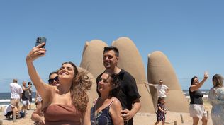 Turistas se toman fotografías junto a la escultura Los dedos este martes, en Punta del Este.&nbsp;