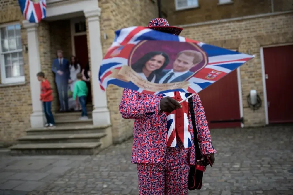 Un patriota británico flamea su bandera con la pareja de novios.