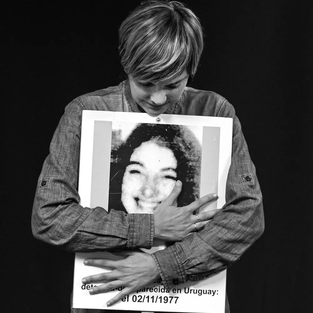 La comunicadora Iliana Da Silva sostiene el cartel con el rostro de la desaparecida Amelia Sanjurjo.