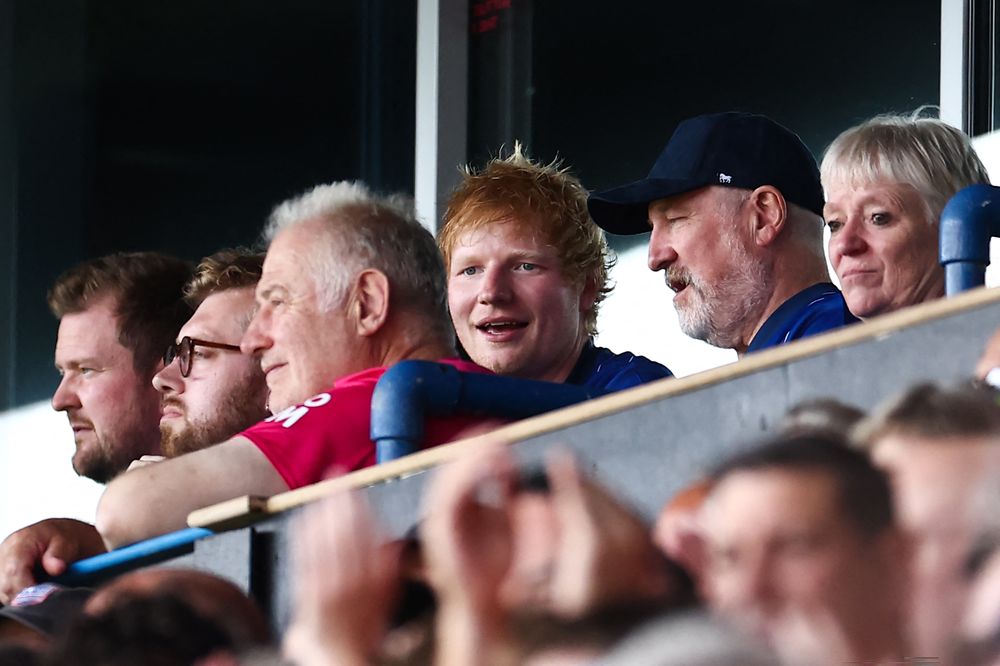 El cantante británico Ed Sheeran (centro) asiste al partido de fútbol de la Premier League inglesa entre Ipswich Town y Liverpool en Portman Road en Ipswich