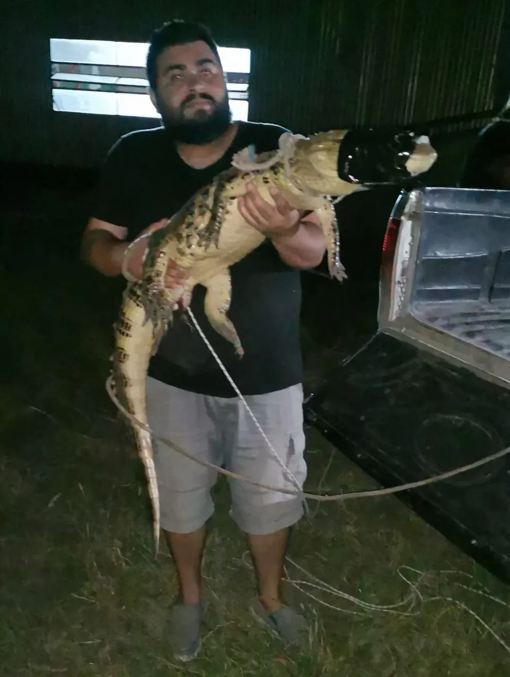 Leonardo Ludueña, encargado de Serpentario Fray Bentos junto al yacaré capturado