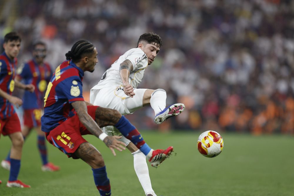 El delantero de Barcelona Raphinha disputa un balón con el mediocampista de Real Madrid Federico Valverde durante la final de la Supercopa Española