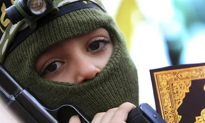 Líbano- Un niño con una copia del Corán y una pistola participa en una manifestación pro palestinos