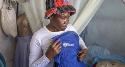 Trabajadora comunitaria de salud muestra una chaqueta de USAID que solía usar, en Harare Zimbabue.