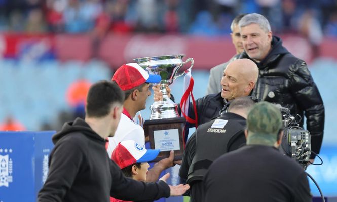 Diego Polenta de Nacional recibe la copa de Aldo Gioia; Alejandro Balbi aparece atrás