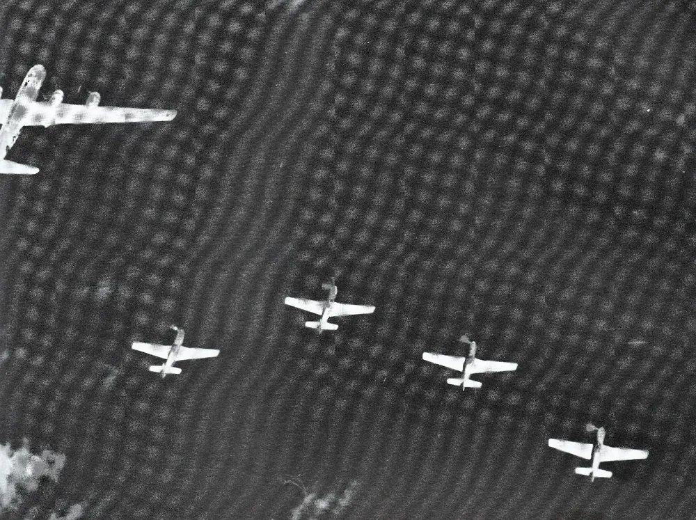 Un B-29, arriba a la izquierda, escoltado por cazas Mustang P-51, se dirige a bombardear Japón