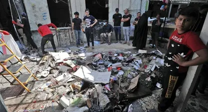 Ciudadanos iraquíes inspeccionan el lugar de la explosión