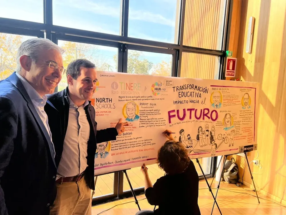 Robert Silva y Agustín Porres, director regional de Fundación Varkey, mientras la ilustradora sigue con su trabajo