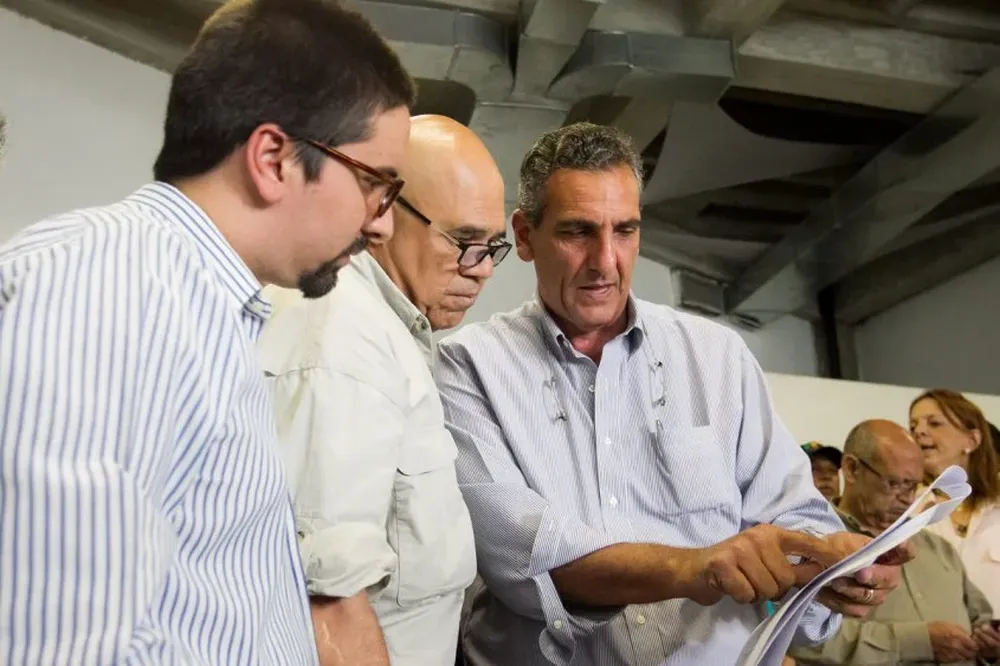 El exalcalde Vicenzo Serrano muestra un documento a Jesús Torrealba, dirigente de la MUD