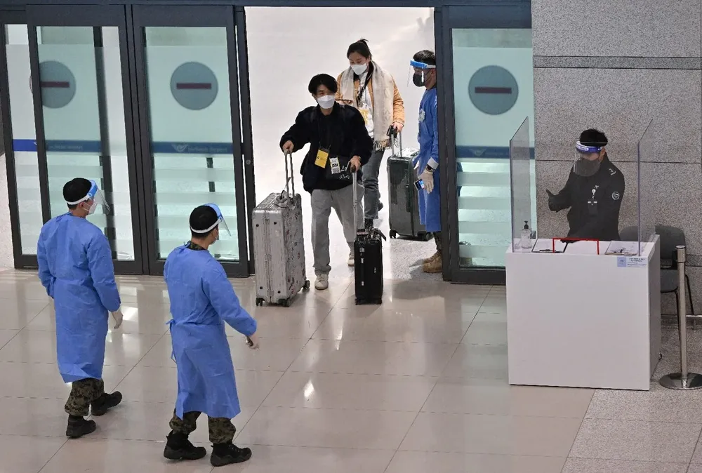 Médicos guían a viajeros provenientes de China en el aeropuerto de Corea del Sur