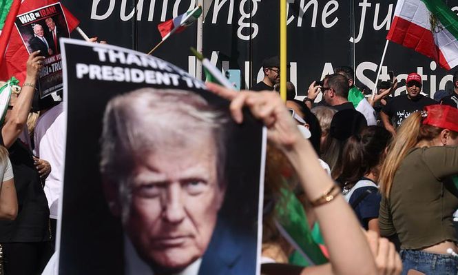 Manifestantes de la comunidad iraní en Los Ángeles, California, ondea banderas y pancartas con la imagen de Trump en apoyo a  los ataques contra Irán.