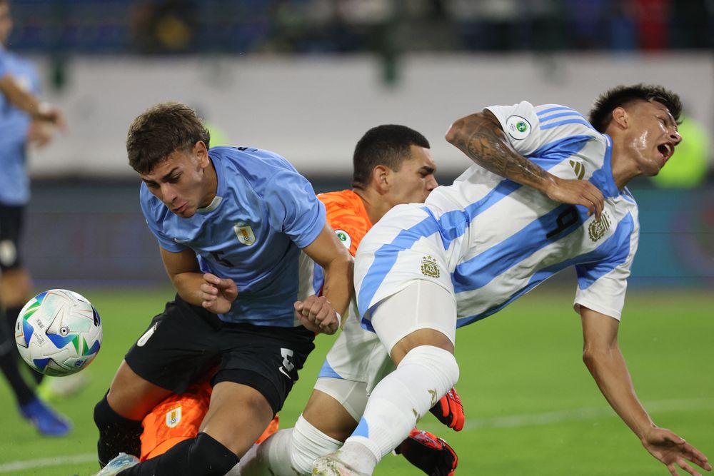 Juan Rodríguez, Agustín Ruberto y el golero uruguayo Kevin Martínez en el momento del choque que le provocó una lesión al argentino en el Sudamericano sub 20 de Venezuela