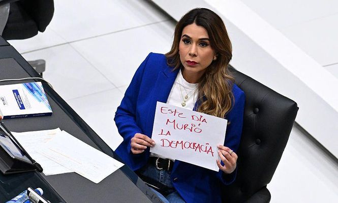 La diputada opositora de ARENA, Marcela Villatoro, con un cartel que dice "Hoy murió la democracia" durante una sesión plenaria del Congreso en San Salvador.