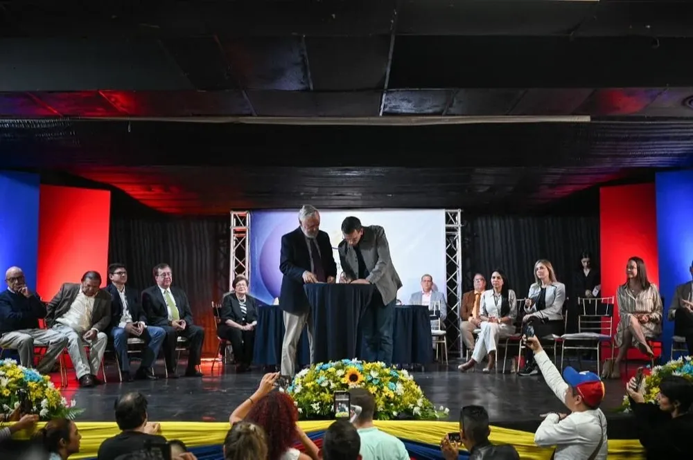 El precandidato Henrique Capriles firma el documento unitario de la oposición venezolana.